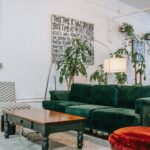 Exposed Fire Sprinkler Pipes Attached to Ceiling in a Room with a Coffee Table, Green Couch and Red Chair