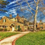 Upscale brick home with barren tree in yard.