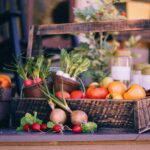 Basket of vegetables with radishes, tomatoes, and carrots.